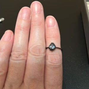 Purple, blue, green stone, black setting with black stone surrounding setting